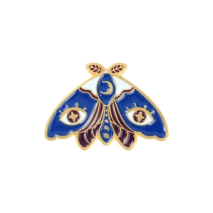Détail d'une broche papillon en émail avec motifs d'étoiles et lune célestes