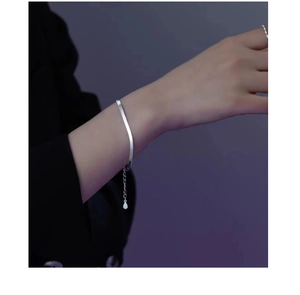 Close-up of a minimalist silver snake bone chain bracelet with an adjustable extension link