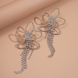 Detailed view of silver flower earrings featuring sparkling rhinestones and long tassels