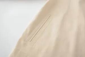 Detailed view of high-quality stitching on a cream white twill fabric welt pocket