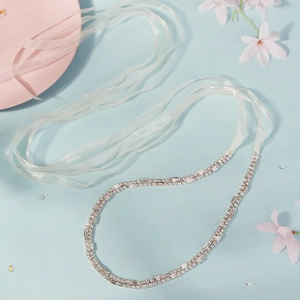Close-up of bridal rhinestone belt and headband with silver crystals and silk ribbon