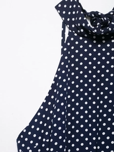 Close-up of navy polka dot midi dress showing halter neckline and chiffon fabric detail