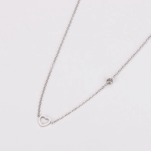 Detail of silver stainless steel necklace with hollow heart pendant and inset diamond