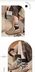 Macro shot of knitted fair isle wool socks featuring cute cartoon dog and snowflake patterns
