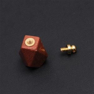 Macro shot of a polygonal tiger eye perfume bottle pendant with golden screw cap details