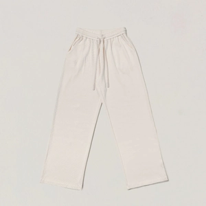 Close-up of beige ribbed knit wide-leg trousers featuring elastic drawstring waistband
