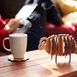 Macro view of flower-shaped wooden coasters stored in a creative sheep-shaped holder