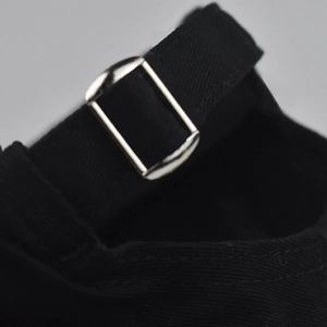 Detailed close-up of the adjustable metal buckle and black fabric strap on a baseball cap