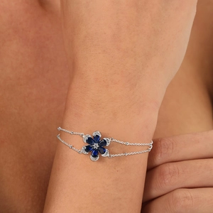 Double-layer silver chain bracelet featuring a blue zircon flower on a model's wrist