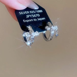 Close-up of 925 silver hoop earrings with cross pendants and vintage embossed textures