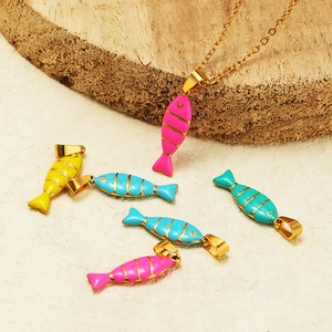 Golden fish enamel charms in pink and blue for DIY necklace jewelry making on wood