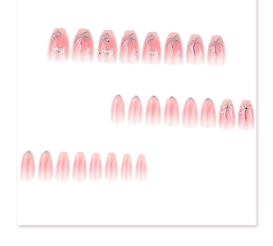 Detail of pink gradient press-on nails with silver ribbon design and small rhinestones