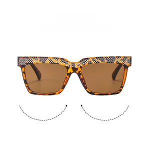 Close-up of tortoise shell frame sunglasses with luxury rhinestone inlay and brown lenses
