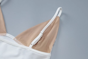 Gros plan sur la bretelle réglable et la dentelle d'un haut court blanc pour femme