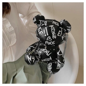 Detail of a graffiti teddy bear crossbody bag with silver chain strap and letter prints