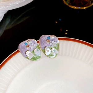 Vintage floral drop oil stud earrings with mother of pearl and beads on white ceramic plate