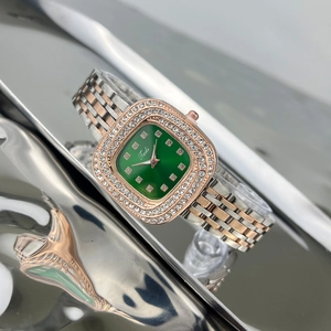 Close-up of a square green face watch with rose gold crystal bezel and two-tone metal band