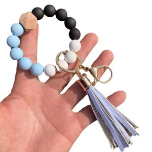 Light blue and black silicone beaded wristlet keychain with wood bead and purple tassel