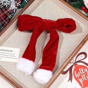Close-up of a festive red velvet Christmas hair scrunchie with white plush pom-pom detail