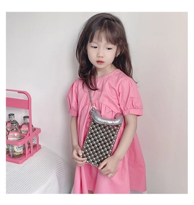 Dettaglio di un vestito rosa da bambina con una borsa a tracolla con perline d'argento