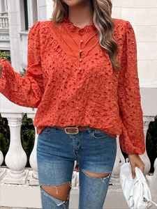 Detail of hollow embroidery cotton fabric and ruffle stand collar on orange women blouse