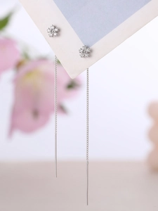 Macro detail of silver snowflake tassel earrings with sparkling zircon crystals