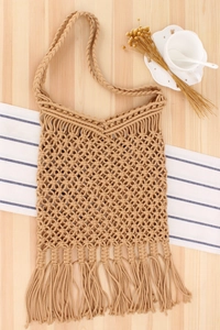 Detail of handmade macrame hollow weave shoulder bag with long fringe and bohemian style