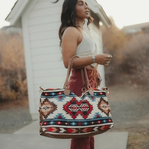 Close-up of ethnic geometric pattern canvas tote bag with brown leather handle in outdoor light