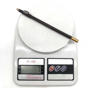 Detailed macro shot of a 7g barber pencil with built-in sharpener on a scale