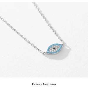 Macro view of S925 sterling silver evil eye pendant with blue beads and white zircon stones