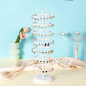 Rotating white metal tiered earring organizer stand with multiple jewelry hooks