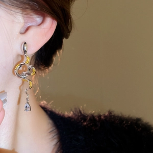 Macro detail of snake drop earring with silver finish and sparkling crystal pendant