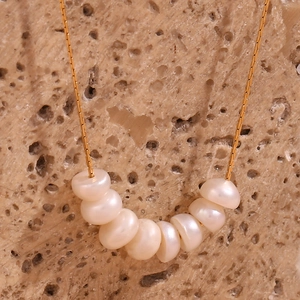 Primer plano de un collar bañado en oro de 18 quilates con siete perlas de agua dulce
