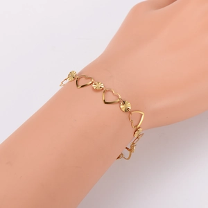Bracelet à maillons cœur doré avec breloques circulaires texturées sur le poignet