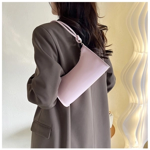 Pink glossy faux leather hobo bag with knotted shoulder strap detail on a female model