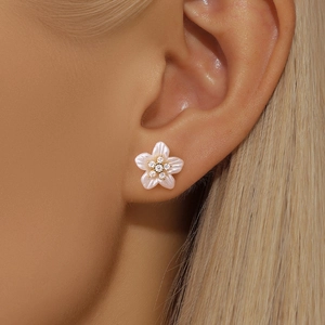 Close-up of elegant pale pink five-petal flower stud earring with zircon core on model ear