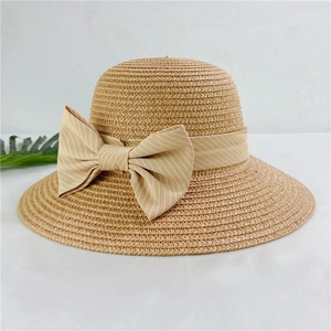 Women straw sun hat with elegant bow ribbon on a minimal light gray background