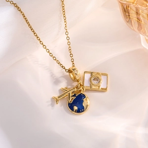 Detailed view of travel charms including golden airplane and blue enamel globe on a chain