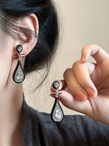 Detail of vintage black enamel drop earrings with water-drop cubic zirconia stones