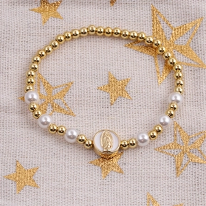 Bohemian copper bead and pearl bracelet with gold Virgin Mary pendant on mesh background