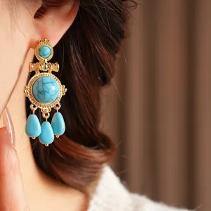 Vintage style gold earrings with turquoise stones and three teardrop-shaped pendants