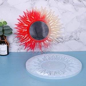 Detail showing sun-shaped silicone mold and finished resin mirror with radial design