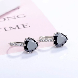 Close-up of heart-shaped black gemstone earrings with pavé white zircon in silver setting