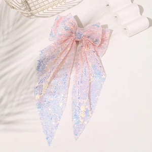 Close-up of pink mesh hair bow with iridescent sequins and long streamers