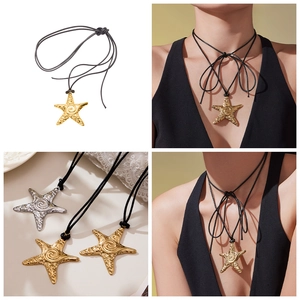 Gros plan de pendentifs étoile de mer dorés et argentés avec texture sur cordon noir