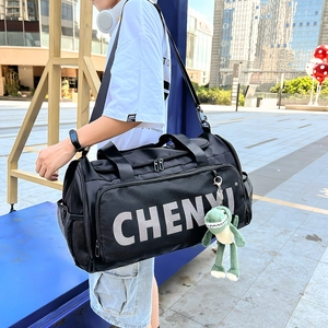 Détail du sac de sport en nylon noir brillant avec porte-clé dinosaure vert mignon
