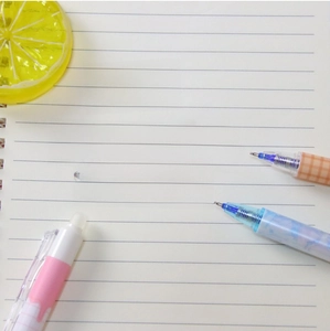 Detail showing retractable erasable gel pens with ST tip and large ink capacity on a notebook