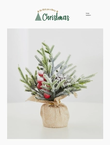 Detail of mini desktop Christmas tree with red berries, snow coating and burlap base