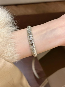 Detail of vintage French style open bangle featuring zircon floral patterns and brushed finish