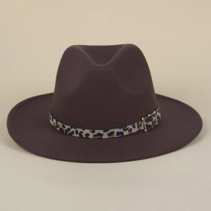 Close-up of leopard print band and golden buckle on dark brown wool felt fedora hat